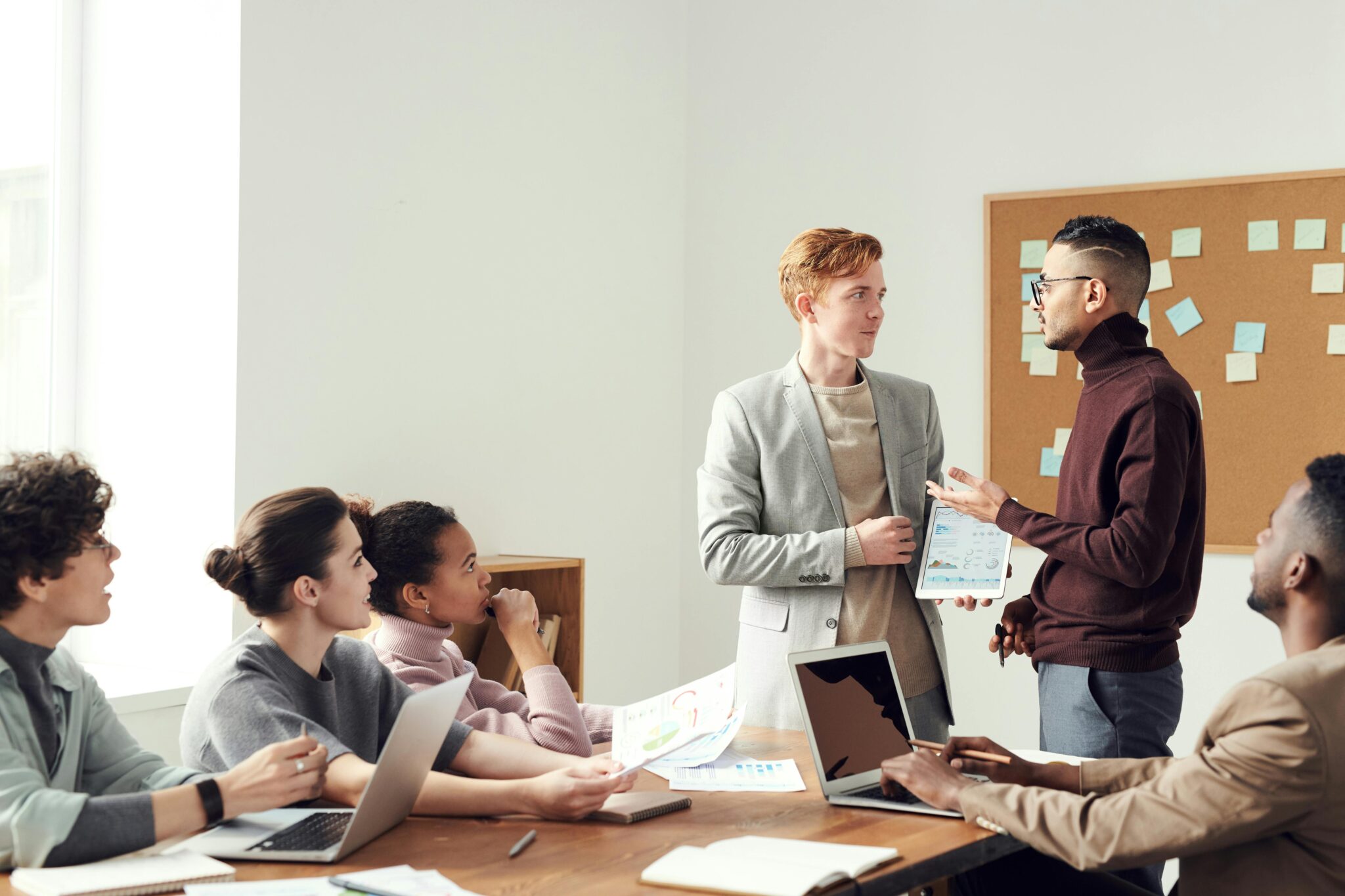 A group of professionals collaborating in a modern office meeting room, exchanging ideas.